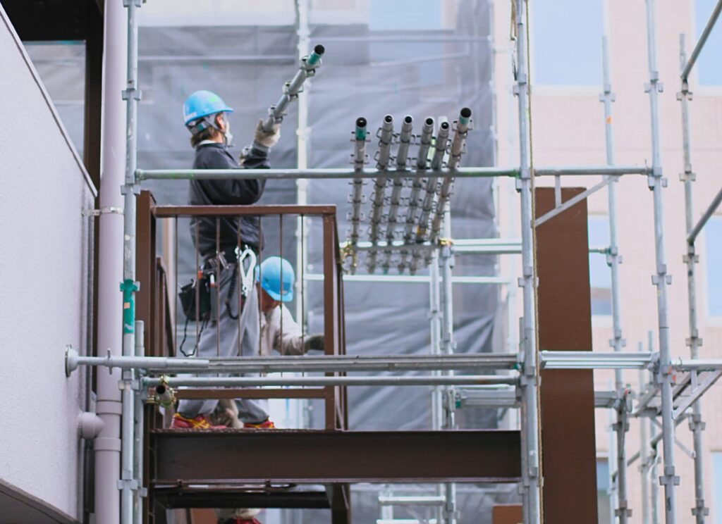 作業員が足場の設置をしている画像